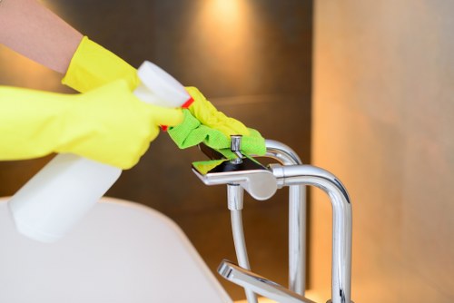 Oven cleaner wearing PPE during a kitchen cleaning task